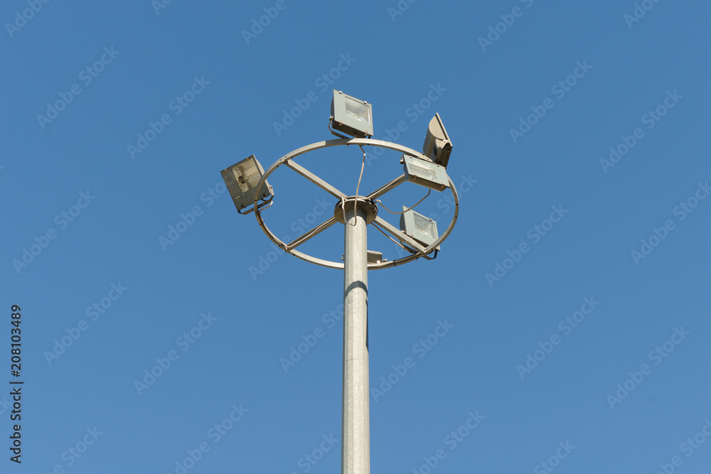 concrete column with several searchlights on a blue sky background concrete column with several searchlights on a blue sky background