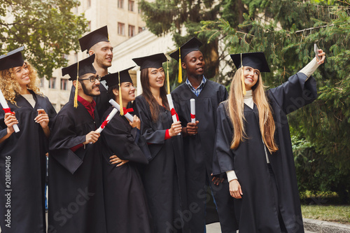 Group of graduates celebrating and making selfie