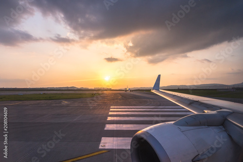 runway with airplane during sunset