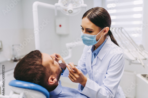 dentist checking patient teeth photo