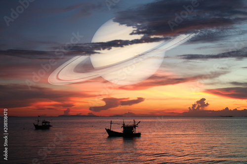 Fototapeta Naklejka Na Ścianę i Meble -  Saturn back on night cloud sunset sky silhouette boat on sea