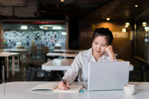 Serious beautiful woman using notebook computer and hand touching face to thinking new ideas for new business project plan. Businesswoman working on laptop and creating new idea strategy at desk.