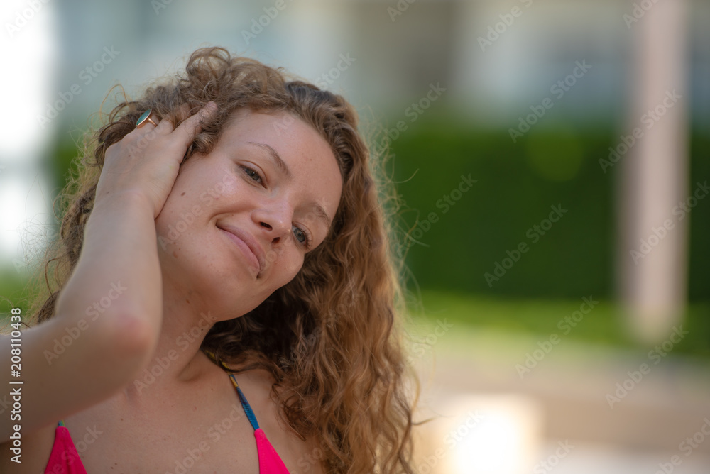 Fototapeta premium Portrait happy woman with long blonde curly hair, hairstyles for dresses concept.