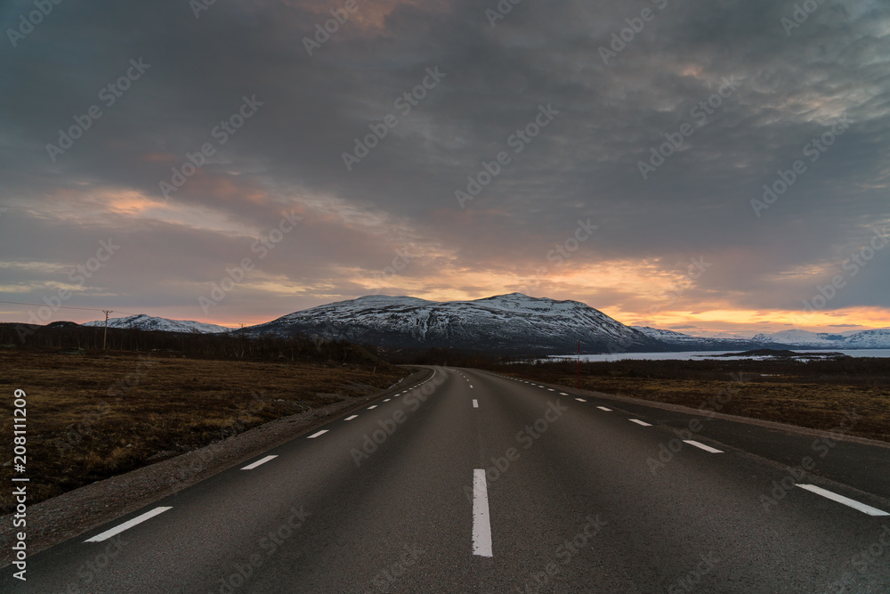 Naklejka premium Road in Abisko National Park and Torneträsk Lake at sunset / Lapland, Sweden