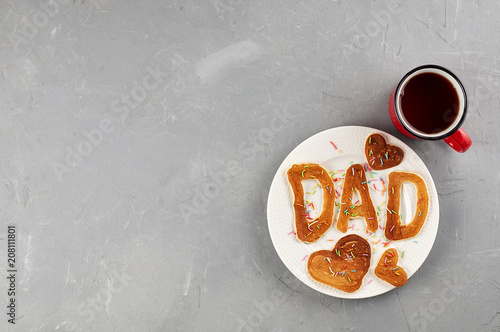 Obraz na płótnie Special Father's Day breakfast. Alphabet Pancakes with sprinkles on white round plate and cup of tea w salonie