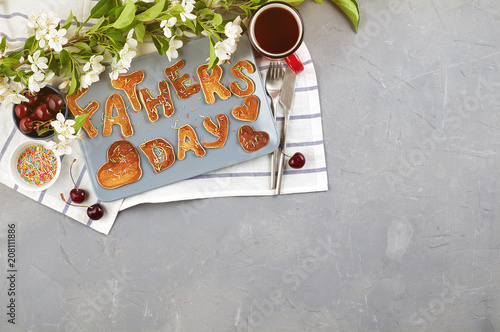 Obraz na płótnie Special Father's Day breakfast. Alphabet Pancakes with sprinkles, cherries and cup of tea on a gray concrete background w salonie