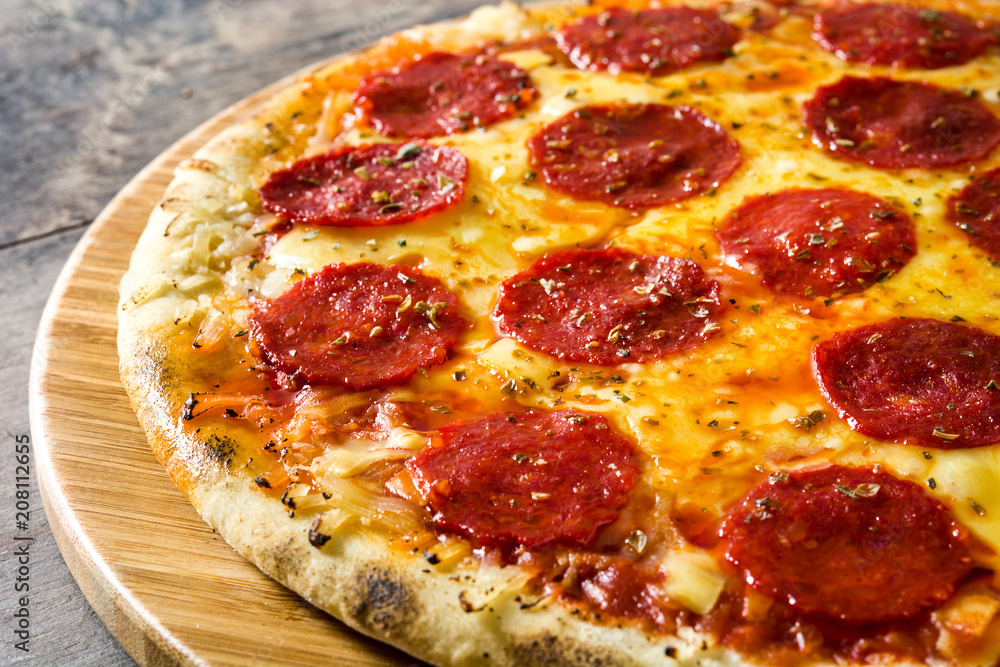 Hot italian pepperoni pizza on wooden table Hot italian pepperoni pizza on wooden table