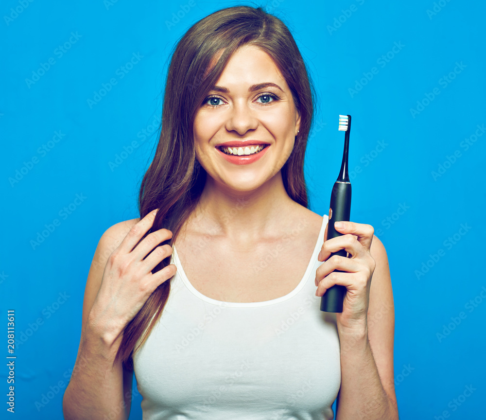 Woman with healthy teeth holding electric toothbrush. Woman with healthy teeth holding electric toothbrush.