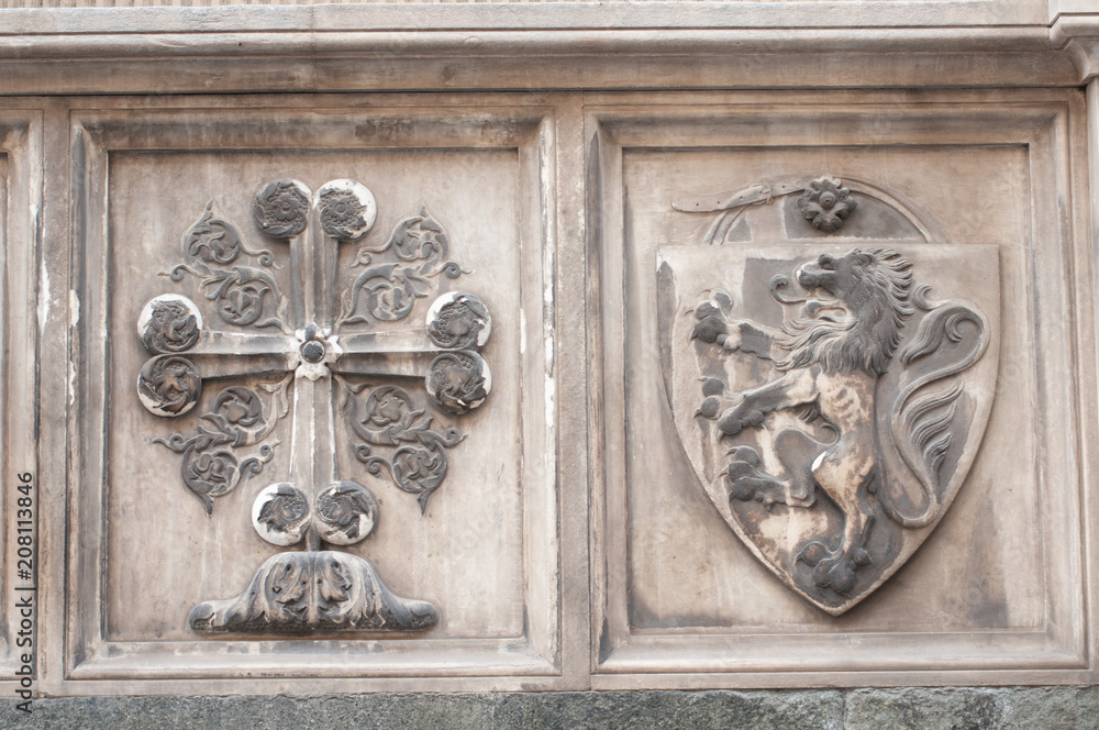 Detail of the Basilica of Santa Maria Novella - famous landmark of Florence, Italy. Cross and shield