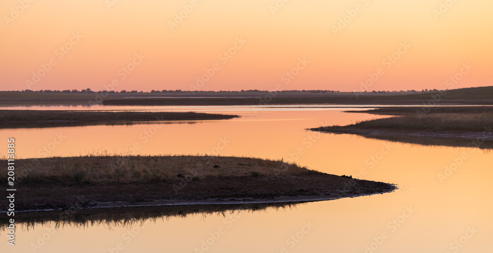Beautiful sunset over the lake and field Beautiful sunset over the lake and field
