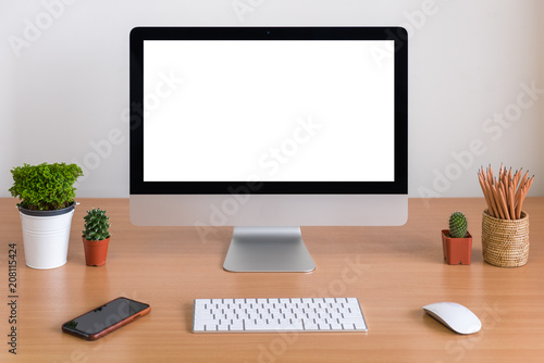 Computer all in one, keyboard, mouse, smartphone, pencils, cactus and plants vase on wooden table