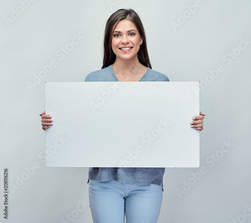 Smiling woman holding white advertising board with empty copy sp