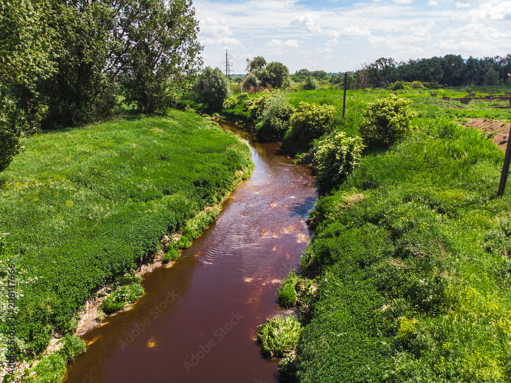 dirty brown river. pollution concept. green riverside dirty brown river. pollution concept. green riverside