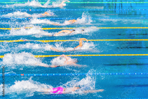 Young swimmers in outdoor swimming pool during competition. Health and fitness lifestyle concept with kids.
