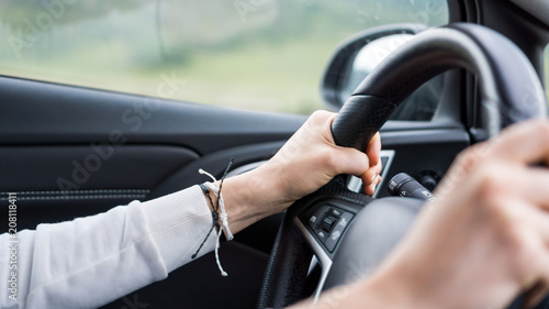 the man holds his hands on the steering wheel, drives the car