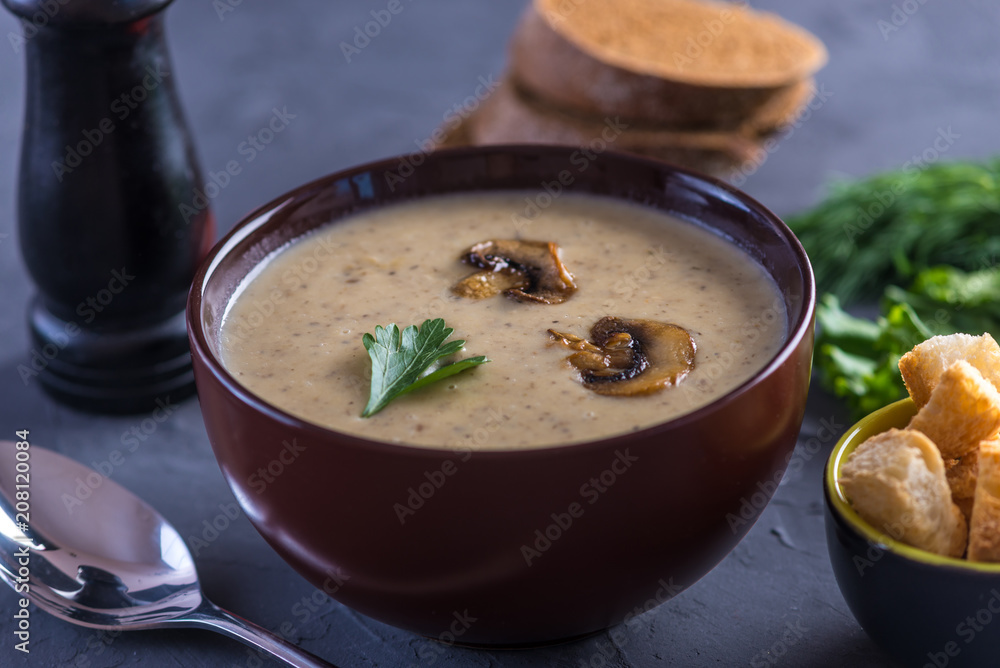 Mushroom cream soup in a brown plate on the table. Healthy autumn vegetarian dish Mushroom cream soup in a brown plate on the table. Healthy autumn vegetarian dish