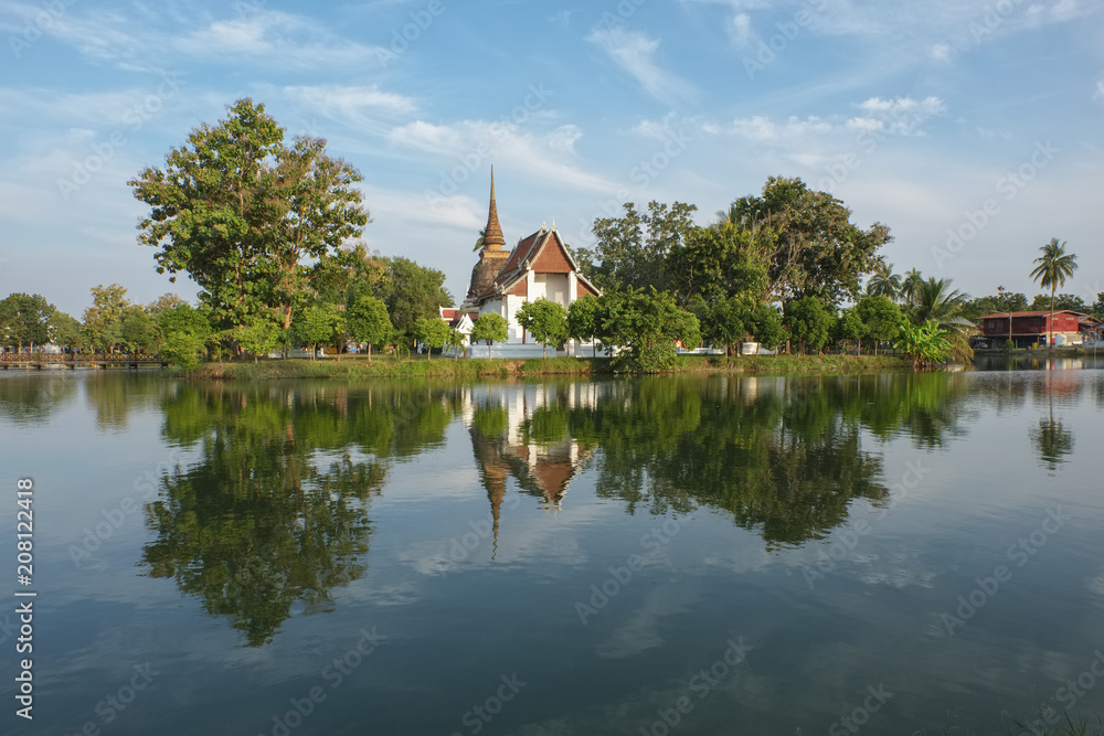 une petit temple bouddhiste qui ce reflète sur un étang dans le parc historique de sukhothai