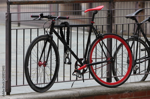 a fixed gear bicylce, locked to a fence