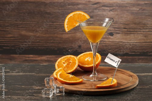 sok pomarańczowy w kieliszku i napis witamina C