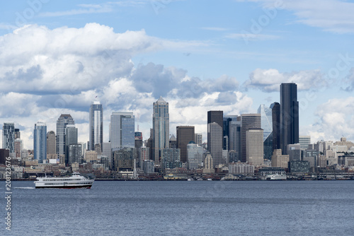 Seattle skyline with boat on Elliott bay under afternoon partly cloudy clouds © Richard