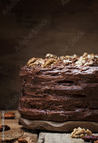 Homemade chocolate cake with nuts, rustic background, selective focus