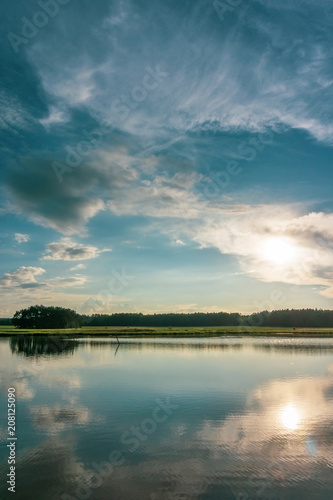 Fototapeta Naklejka Na Ścianę i Meble -  Evening scene in summer near the pond with dramatic sky above