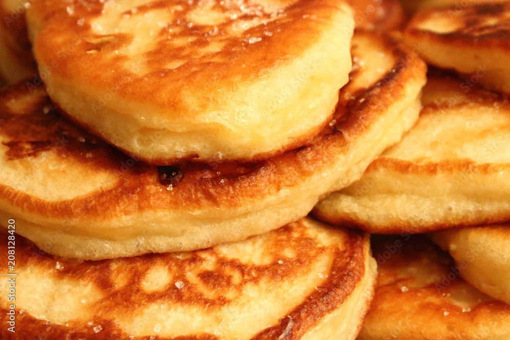 Pancakes with milk sprinkled with sugar. Fritters close-up.
