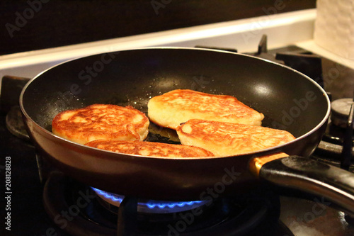 Preparation of pancakes in a frying pan on a gas stove. Pancakes with milk. Close-up.