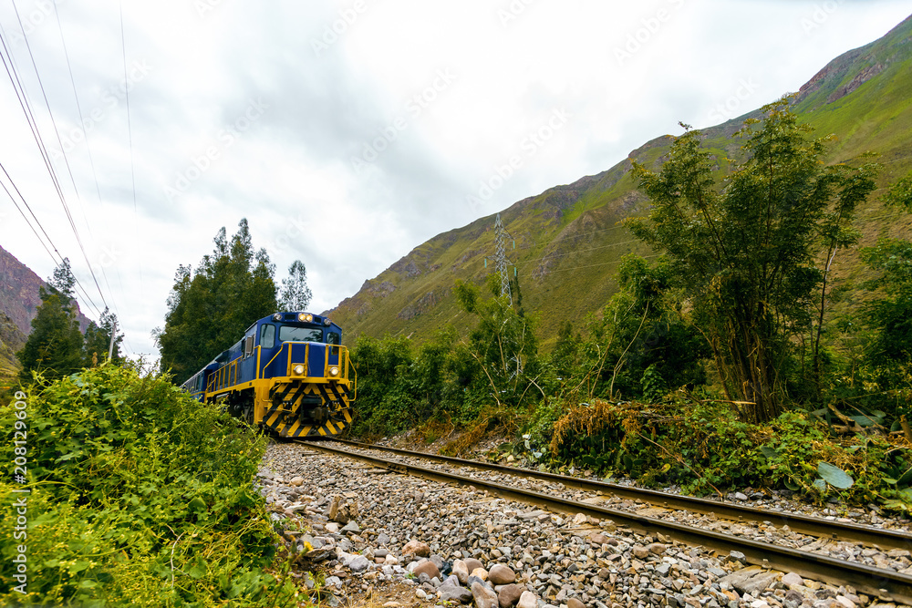 Fototapeta premium Train between the mountains heads to Machu Picchu from Ollantaytambo (Peru)