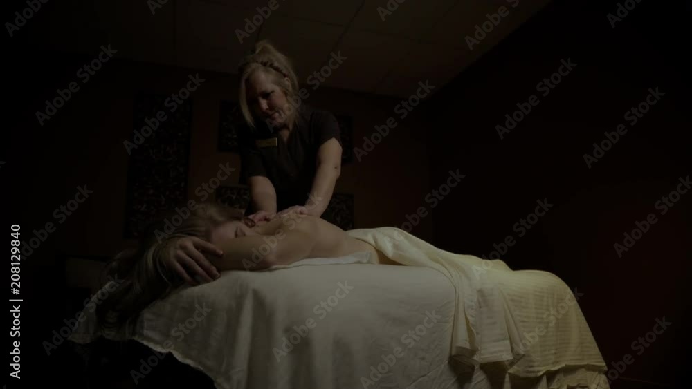 Young female getting a back and head massage with hands and hot stones Young female getting a back and head massage with hands and hot stones