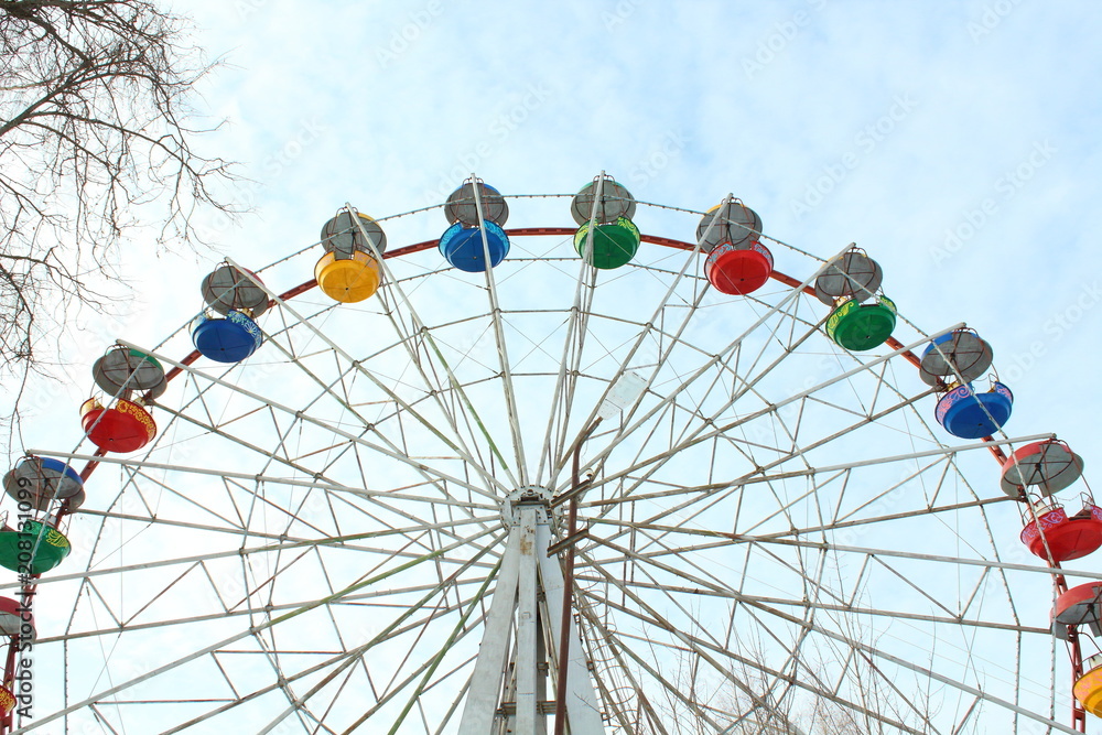 An old colored Ferris wheel in the city park. Close-up. Russia, February, 2018. An old colored Ferris wheel in the city park. Close-up. Russia, February, 2018.