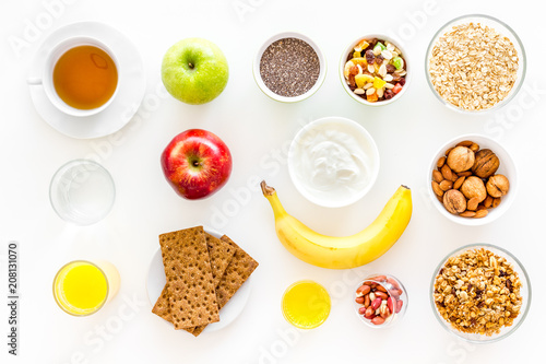 Ingredients for healthy breakfast. Fruits  oatmeal  yogurt  nuts  crispbreads  chia on white background top view