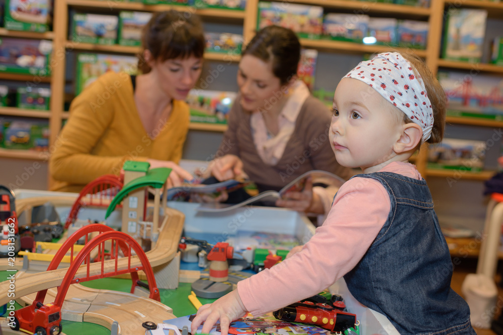 mother and daughter with attractive vendor in toy store mother and daughter with attractive vendor in toy store