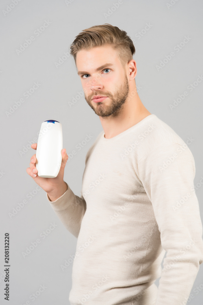 Man confident face holds shampoo bottle, grey background. Guy with bristle holds bottle shampoo, copy space. Hair care and beauty supplies concept. Man enjoy freshness after washing hair with shampoo Man confident face holds shampoo bottle, grey background. Guy with bristle holds bottle shampoo, copy space. Hair care and beauty supplies concept. Man enjoy freshness after washing hair with shampoo