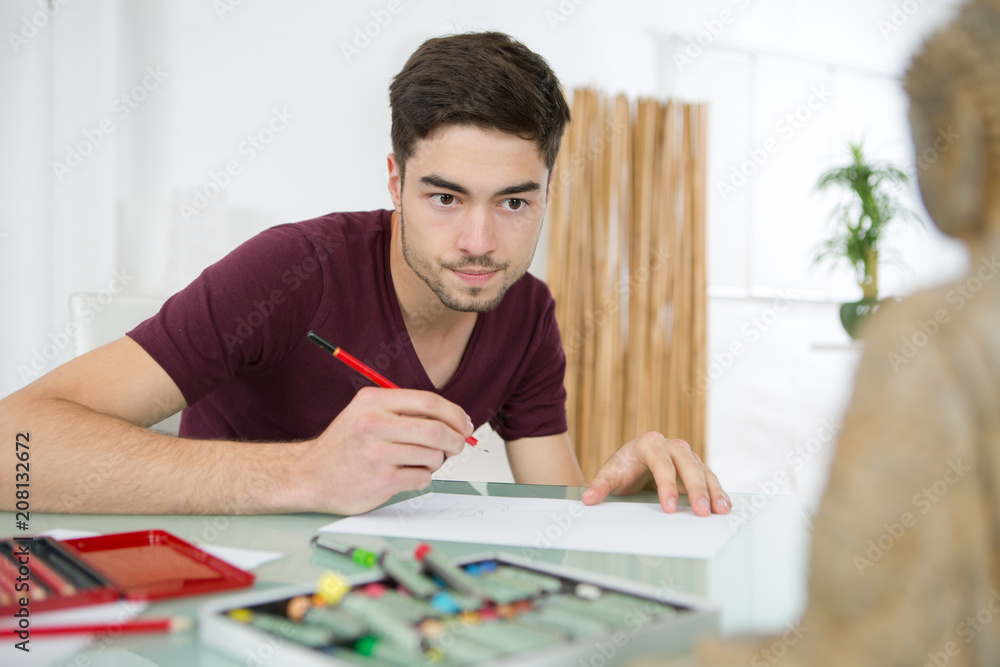 young man drawing pictures in studio young man drawing pictures in studio