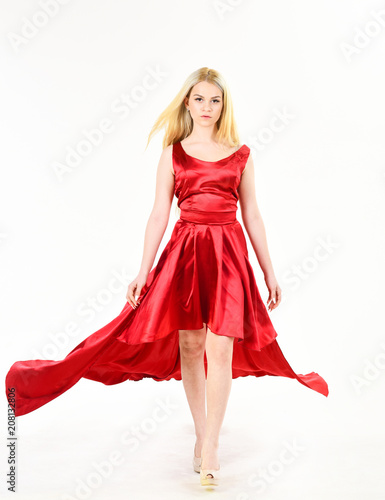 Dress rent service, fashion industry. Dress rent concept. Woman wears elegant evening red dress, white background. Lady rented fashionable dress for visiting event.Girl blonde posing in dress.