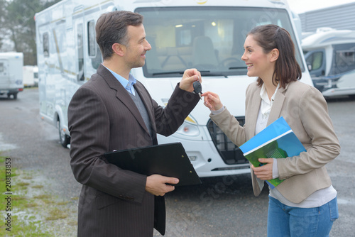 Konstfotografi Salesman handing motorhome keys to woman