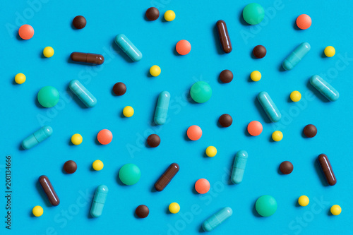 Colorful pills scattered on the blue background
