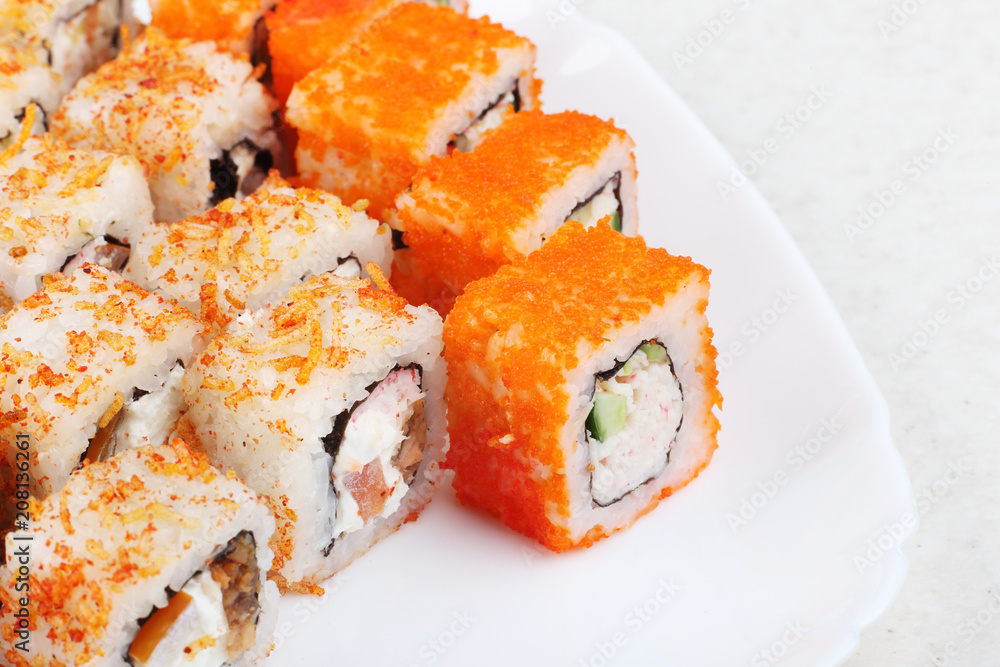Fresh appetizing rolls on a white plate. A bright photo of Japanese food. Close-up of a selective focus. Fresh appetizing rolls on a white plate. A bright photo of Japanese food. Close-up of a selective focus.