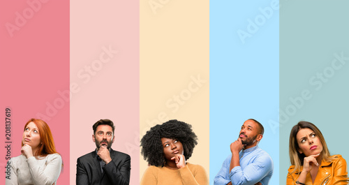 Cool group of people, woman and man thinking and looking up expressing doubt and wonder photo