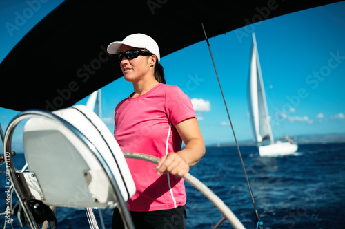 Happy strong woman sailing with her boat