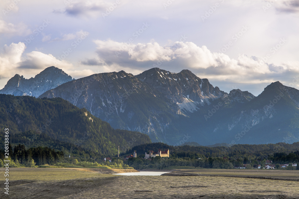 View over the bottom of the dried Forggensee on the Alps in the evening light