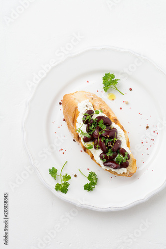 Sandwich with red beans, garlic, olive oil and curd cheese on white background. Mexican Cuisine. Top view.