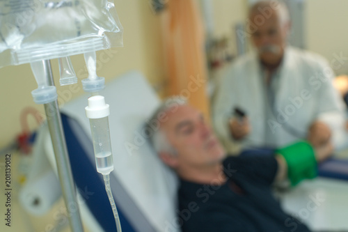 saline solutions bottle hanging and dripping in hospital photo