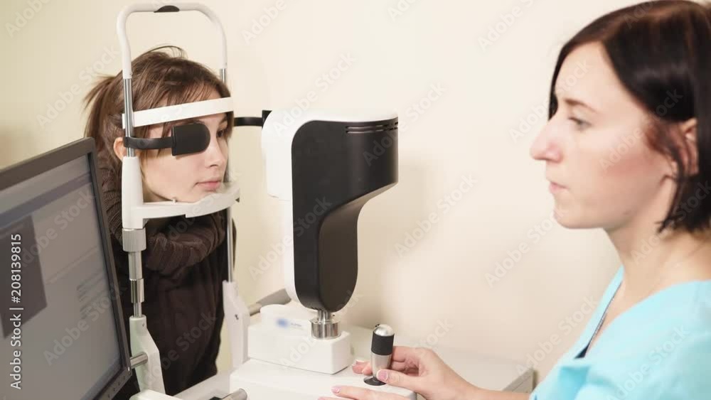 a portrait of a doctor who works in a polyclinic, a nurse adjusts the apparatus for biomicroscopy of the eye, an ophthalmologist looks for pathology a portrait of a doctor who works in a polyclinic, a nurse adjusts the apparatus for biomicroscopy of the eye, an ophthalmologist looks for pathology