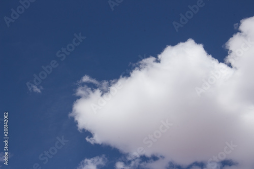 white fluffy clouds on clear blue sky background