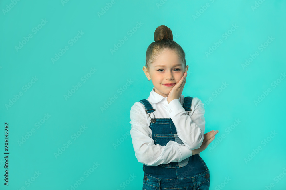 beautiful little happy girl in jeans and a white shirt on a blue background beautiful little happy girl in jeans and a white shirt on a blue background