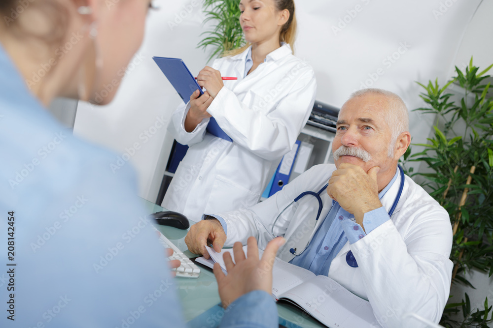 senior doctor discussing health concerns with a woman senior doctor discussing health concerns with a woman