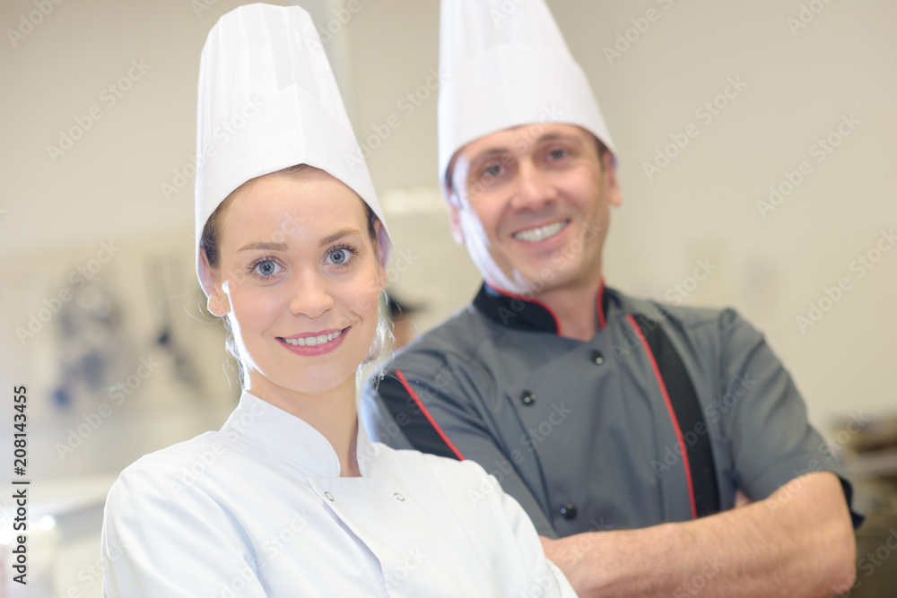 chef instructing trainee in restaurant kitchen