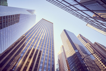 Looking up at Manhattan skyscrapers at sunset, color toned picture, NYC.